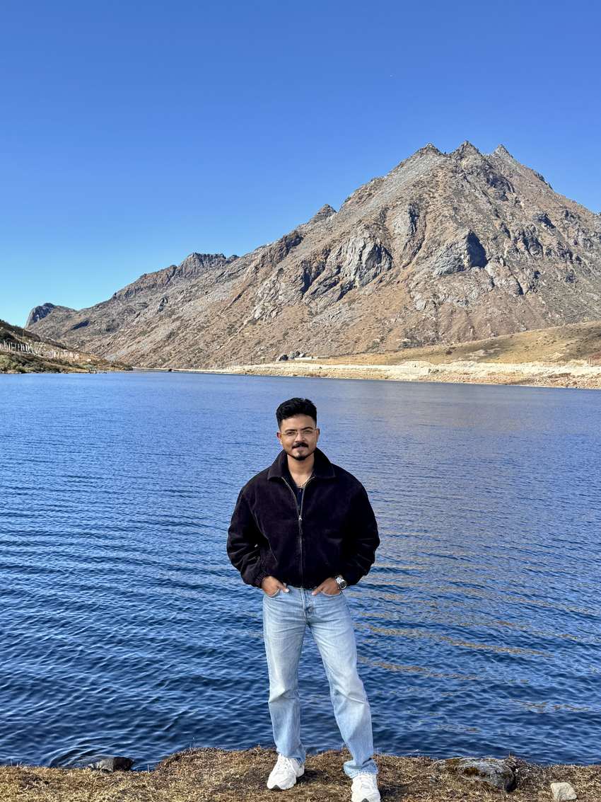 Rudrangshu standing before a high-altitude lake near Sela Pass in the Eastern Himalayas