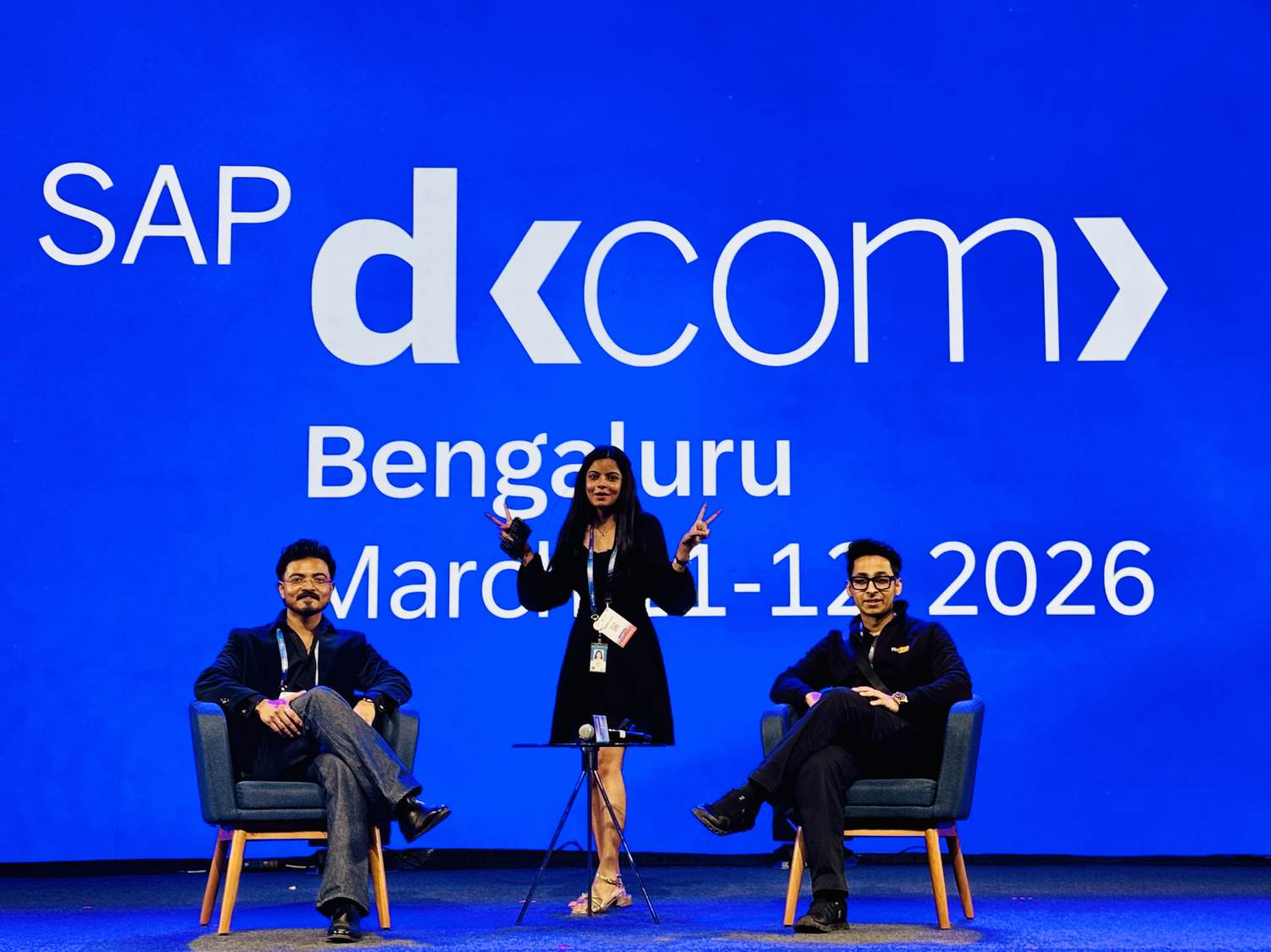 Rudrangshu on stage at SAP D-Com Bengaluru 2026 with two co-panelists